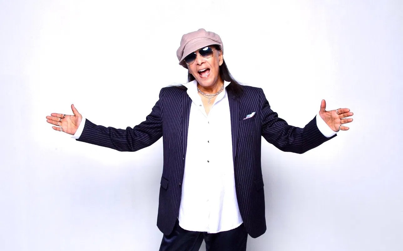 Dato Shake in 2026, arms open in a pinstripe jacket